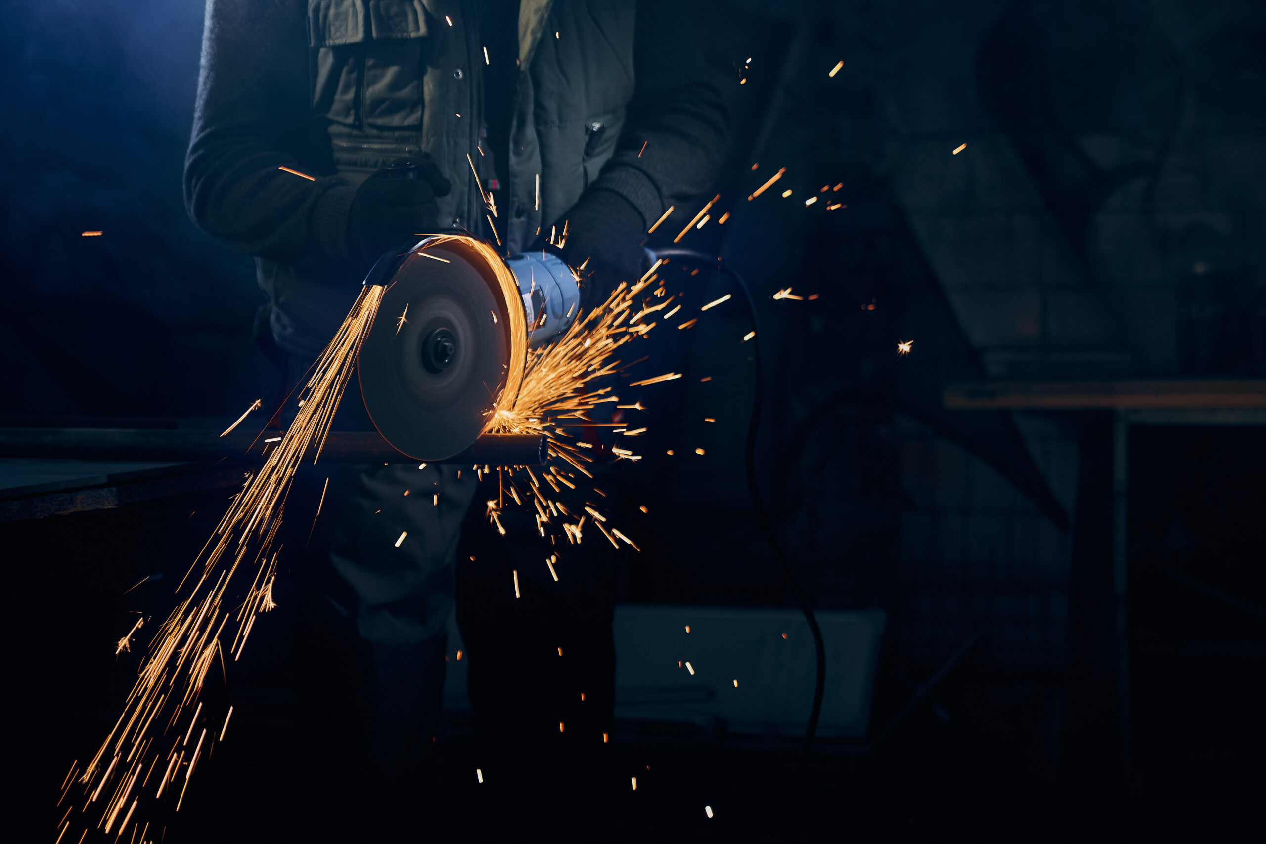 young-man-cutting-with-rotating-disc-metal-with-sparks-scaled.jpg